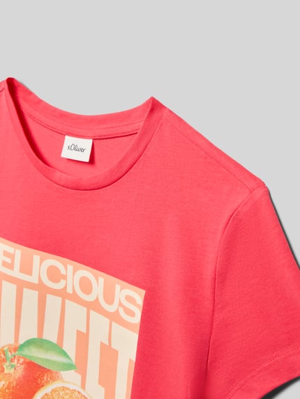 Mädchen trägt Loose Fit T-Shirt aus reiner Baumwolle von s.Oliver RED LABEL, unifarbenes Jersey mit Frontprint, Nahaufnahme Oberkörper.