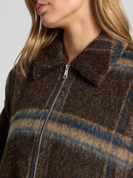 Frauenmodel trägt Regular Fit Blouson mit Umlegekragen Modell 'KATE' von ONLY, braun-blau kariert, weiche Textur, Nahaufnahme Oberkörper, Damen Bomberjacke / Blouson von ONLY