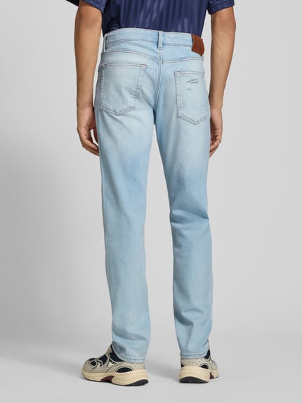 Mężczyzna nosi Slim Fit Jeans aus Baumwoll-Mix von Calvin Klein Jeans, jasnoniebieski, gładka faktura, widok całej sylwetki z tyłu.