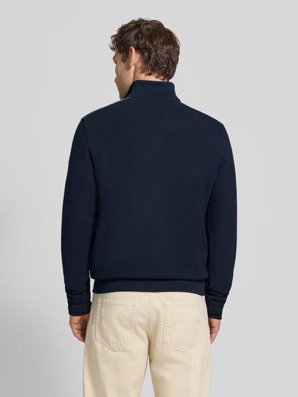 Männermodel trägt Sweatshirt mit Label-Details von bugatti in Dunkelblau, gerader Schnitt, Rückenansicht, Ganzkörperansicht Rückansicht. Elastischer Material-Mix mit Baumwoll-Anteil, Troyer-Kragen, Brusttasche, Rückenlänge 64 cm, Ärmellänge 66 cm.