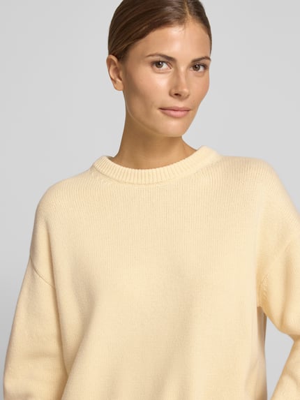 Frauenmodel trägt Strickpullover aus Woll-Mix Modell 'GRISUC' von MANGO in Creme, Rundhalsausschnitt, Relaxed Fit, Nahaufnahme Oberkörper.