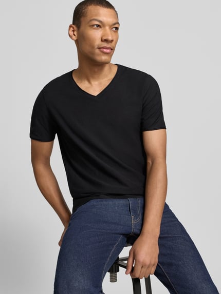 Mężczyzna nosi T-Shirt mit geripptem Rundhalsausschnitt von MCNEAL, kolor czarny, krój regular fit, długość tyłu 65 cm, całkowity widok z przodu.