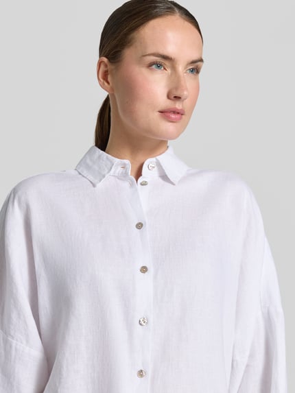 Vrouwenmodel draagt linnen blouse met kentkraag, knoopsluiting, 3/4-mouw, loose fit van Christian Berg Woman, nahaufnahme bovenlichaam.