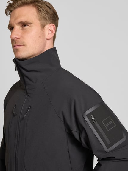 Männermodel trägt Regular Fit Trainingsjacke mit Label Patch Modell 'OW_GLOBE' von BOSS Green, Optik: Unifarben, Nahaufnahme Oberkörper.