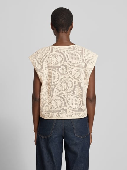 Vrouwenmodel draagt Strickweste met V-hals model 'Crossy' van FREE/QUENT in gebroken wit, embroidery patroon, rechte fit, zuiver katoen, ruglengte maat S 52 cm, knoopsluiting, detailopname rugaanzicht.