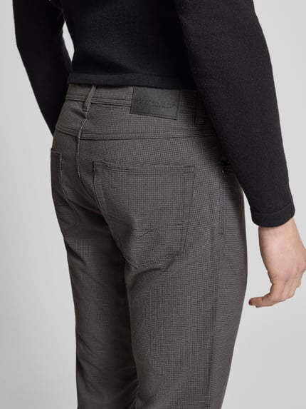Männermodel trägt Chino mit 5-Pocket-Design von Christian Berg Men, Material-Mix mit Viskose-Anteil, Gerader-Schnitt, Detailaufnahme Rückansicht.