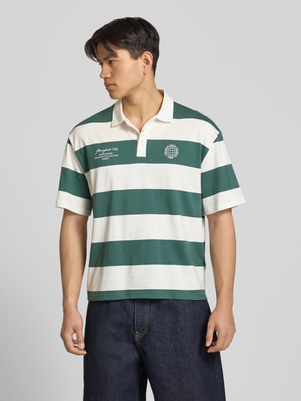 Männermodel trägt Relaxed Fit Poloshirt aus reiner Baumwolle Modell 'DEVIN' von Only & Sons, gestreift, Optik:Allover-Muster, Ganzkörperansicht von vorne.