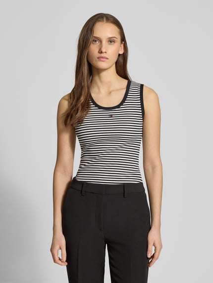 Frauenmodel trägt Slim Fit Tank Top aus Baumwoll-Mix von Tommy Jeans, gestreift, Optik: mehrfarbig, Logo-Detail, Feinripp, U-Ausschnitt, breite Träger, Nahaufnahme Oberkörper.