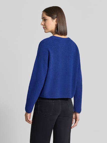 Frauenmodel trägt Relaxed Fit Strickpullover mit Woll-Anteil von Oui in Blau, gerippte Abschlüsse, Langarm, Ganzkörperansicht Rückansicht.