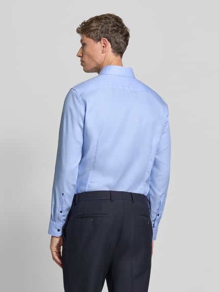 Männermodel trägt Regular Fit Businesshemd mit kontrastierendem Innenkragen von Seidensticker, hellblau, feines Webmuster, Ganzkörperansicht Rückansicht.