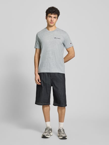 Männermodel trägt Herren T-Shirt mit Logo-Stitchings Modell 'ICONS CONTRAST' von CHAMPION, Baumwoll-Mix, Modern Fit, Ganzkörperansicht von vorne.