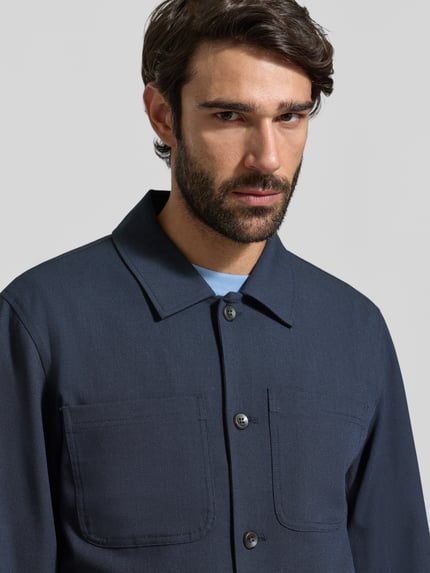 Männermodel trägt Regular Fit Hemdjacke mit borstzakken Model 'Marseille' van Les Deux, materiaalmix met viscose, nahaufnahme oberkörper. Ruglengte maat M 69 cm, schouderbreedte 45 cm, borstwijdte 52 cm, mouwlengte 66 cm.