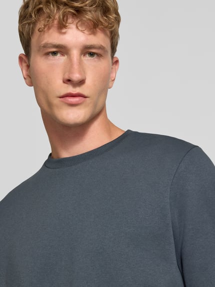 Männermodel trägt Regular Fit Sweatshirt mit Baumwoll-Anteil Modell 'Bradley' von JACK & JONES, Rundhalsausschnitt, Nahaufnahme Oberkörper.