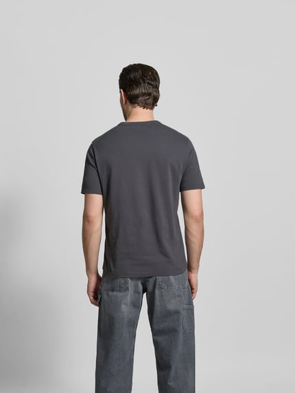 Männermodel trägt Regular Fit T-Shirt aus reiner Baumwolle von Officine Générale, Herren T-Shirt, Rundhalsausschnitt, kurzärmelig, Rückenlänge 66 cm in Größe M, unifarbenes Design, Ganzkörperansicht Rückansicht.