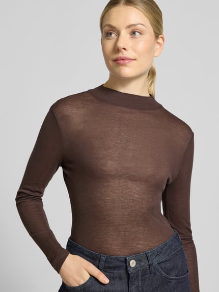 Frauenmodel trägt Langarmshirt aus Viskose-Wolle-Mix von OPUS in Braun, unifarben, Feinstrick, hochgeschlossen, Nahaufnahme Oberkörper.