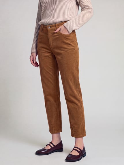 Frauenmodel trägt Regular Fit Cordhose mit Label-Patch Modell 'Bobbie' von MAC in unifarbener Struktur-Optik, 7/8-Länge, Ganzkörperansicht von vorne.