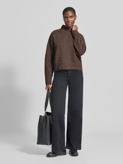 Frauenmodel trägt Turtleneck-Pullover mit Woll-Anteil und Rundhalsausschnitt von Neo Noir, braun, gerader Schnitt, Ganzkörperansicht von vorne.