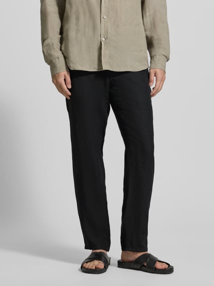Mężczyzna nosi Straight Fit Leinenhose mit Tunnelzug von Brax, czarne, proste lniane spodnie, unikatowa faktura, krój straight fit, tunel w pasie, materiał: czysty len, widok całej sylwetki z przodu.