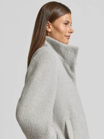 Frauenmodel trägt Regular Fit Jacke mit Strukturmuster von COMMA, Stehkragen, hellgrau, elastische Ärmelabschlüsse, Nahaufnahme Oberkörper.