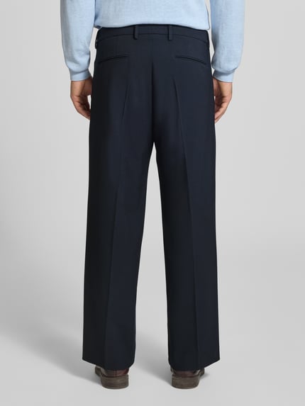 Männermodel trägt Stoffhose mit Bügelfalte Modell 'LEEK' von DRYKORN in Dunkelblau, Material-Mix, Ganzkörperansicht Rückansicht.