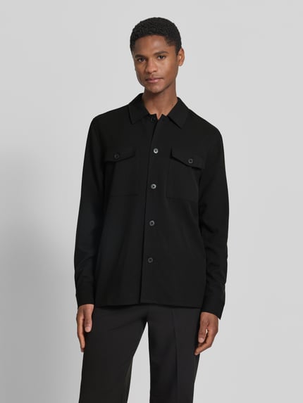 Männermodel trägt Relaxed Fit Hemdjacke mit Brusttaschen von Lindbergh aus Material-Mix mit Viskose-Anteil, Schwarz, Ganzkörperansicht von vorne.