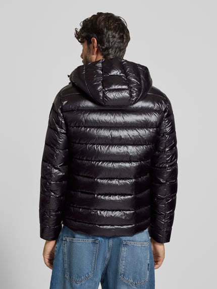 Männermodel trägt Steppjacke mit Zweiwege-Reißverschluss Modell 'ADAMS' von Blauer USA, glänzendes Schwarz, Ganzkörperansicht Rückansicht. Rückenlänge bei Größe M: 66 cm, Schulterbreite: 44 cm, Brustweite: 53 cm, Ärmellänge: 65 cm, Regular Fit, Kapuze mit Tunnelzug, Label-Detail.