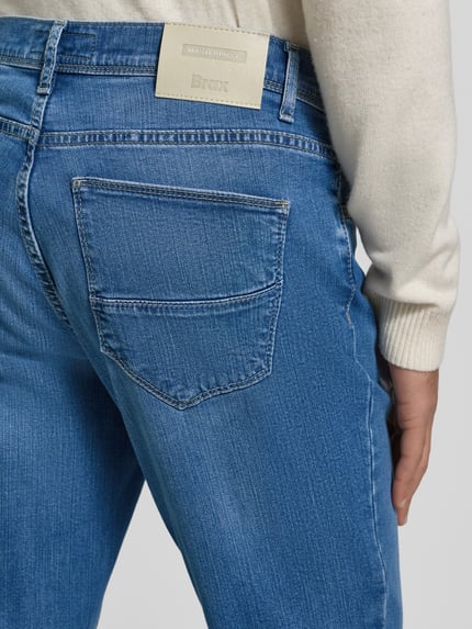 Männermodel trägt Straight Fit Jeans mit 5-Pocket-Design Modell 'Cadiz' von Brax, blauwe denim, labeldetail, katoen-lyocell-mix, detailaufnahme achterzak.