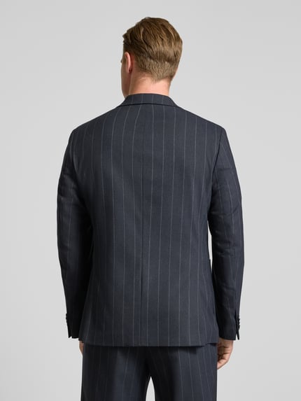Männermodel trägt Sakko mit seitlichen Eingrifftaschen und Reverskragen von MCNEAL, dunkel mit feinen Streifen, Ganzkörperansicht Rückansicht. Regular Fit, Zweireiher, Brustleistentasche, Rückenlänge 74 cm, Schulterbreite 49 cm, Ärmellänge 56 cm.