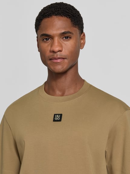 Männermodel trägt Regular Fit T-Shirt aus reiner Baumwolle Modell 'Dalile' von HUGO, beige, glatte Textur, Nahaufnahme Oberkörper, Herren T-Shirt von HUGO