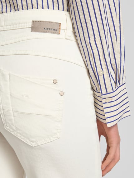Frauenmodel trägt Wide Leg Medium Waist Jeans Modell 'AMELIE' von Gang in Creme mit sichtbaren Nähten, Detailaufnahme Rückansicht, Baumwoll-Mix mit Stretch-Anteil, Eingrifftaschen.