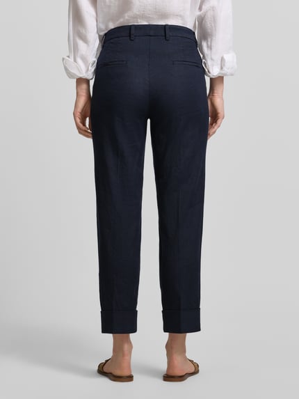 Vrouwenmodel draagt Leinenhose mit Baumwoll-Anteil van Cambio in donkerblauw, straight fit, verkort, met steek- en achterzakken, detailopname rugaanzicht