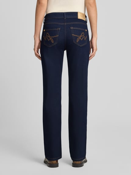 Frauenmodel trägt Straight Fit Jeans aus Baumwoll-Mix Modell 'Carrie' von MAC in dunklem Blau mit beigen Nähten, Ganzkörperansicht Rückansicht, Damen Straight Fit Jeans von MAC.