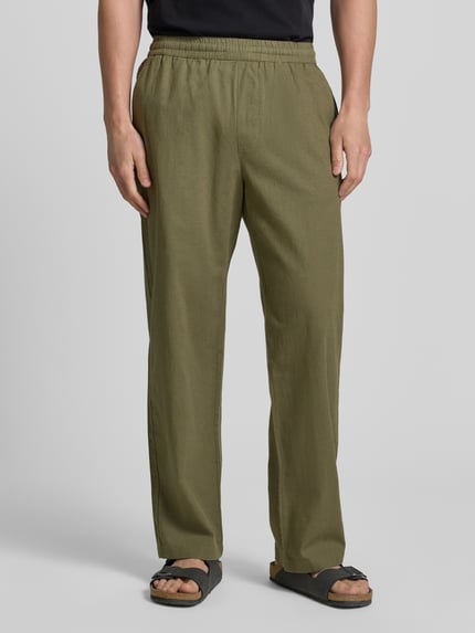 Männermodel trägt Regular Fit Hose mit Eingrifftaschen van Wood Wood, mix van linnen en katoen, olivegroen, elastische band, steekzakken, regular fit, bandwijdte maat M 42 cm, binnenbeenlengte maat M 77 cm, heren broek, ganzkörperansicht van voren