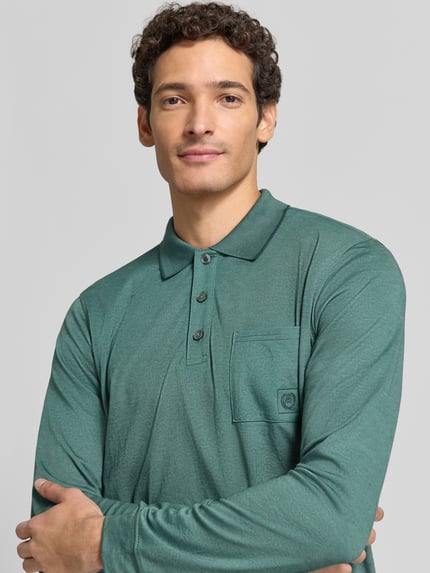 Männermodel trägt Regular Fit Poloshirt in Two-Tone-Machart von LERROS in Grün, Brusttasche, Logo, Knopfleiste, Nahaufnahme Oberkörper, Baumwoll-Mix.