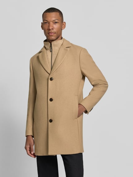Männermodel trägt Regular Fit Mantel aus Woll-Mix mit Viskose-Anteil von Matinique in Beige, Eingrifftaschen, Knopfverschluss, Ganzkörperansicht von vorne.