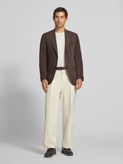 Männermodel trägt Sakko mit Pattentaschen und Reverskragen Modell 'Theo' von Carl Gross aus braunem Cord, Regular Fit, Ganzkörperansicht von vorne.