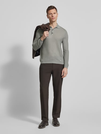 Männermodel trägt Slim Fit Pullover aus Lyocell-Mix mit Schurwoll-Anteil von Emporio Armani, Strick-Optik, Polokragen, Logo-Stitching, Ganzkörperansicht von vorne