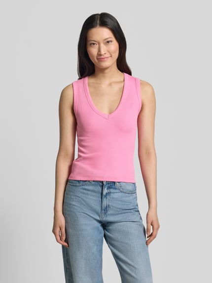 Vrouwenmodel draagt Slim Fit Tank Top uit katoenmix model 'CHLOE' van Vero Moda, effen roze, ribstructuur, brede bandjes, v-hals, vooraanzicht van het volledige lichaam