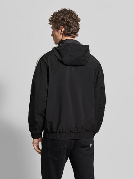 Männermodel trägt Regular Fit Jacke mit Kapuze Modell 'BAVO2621' von HUGO, Optik: Unifarben, elastischer Abschluss, Ganzkörperansicht Rückansicht.