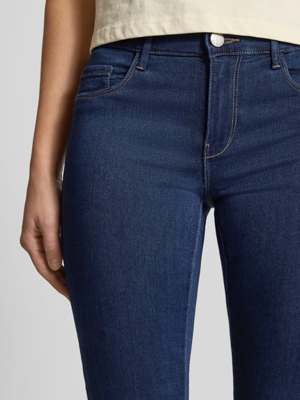 Frauenmodel trägt Skinny Fit Jeans aus Viskosemischung Modell 'Rain' von ONLY, dunkles Blau, 5-Pocket-Design, Baumwoll-Stretch, Nahaufnahme Oberkörper. Innenbeinlänge 82 cm, Bundweite 70 cm, Regular Waist, Knopf-Reißverschluss.