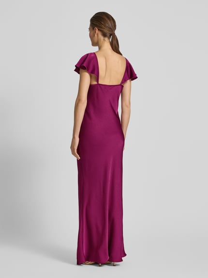 Frauenmodel trägt Fließendes Abendkleid aus Satin Modell 'RITA' von Vero Moda in Optik: Unifarben, Passform: fließend, Maxi-Länge, U-Ausschnitt, Applikation: Satin-Rose, Trägerform: schmale Träger mit Frill, Materialverarbeitung: Satin, Rückansicht Ganzkörperansicht.