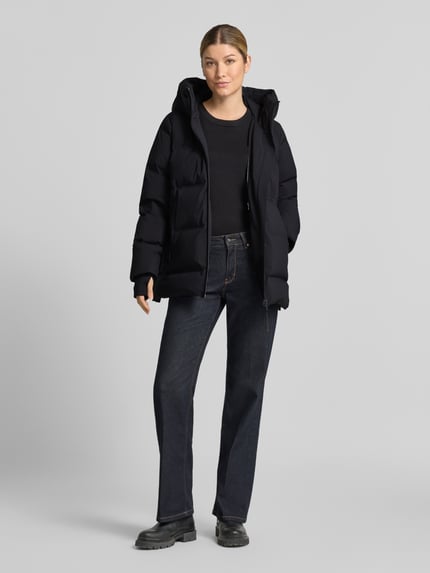 Frauenmodel trägt schwarze Regular Fit Daunenjacke mit abnehmbaren Rucksackgurten von Marc O'Polo, glatte Oberfläche, Ganzkörperansicht von vorne, Damen Daunenjacke von Marc O'Polo.