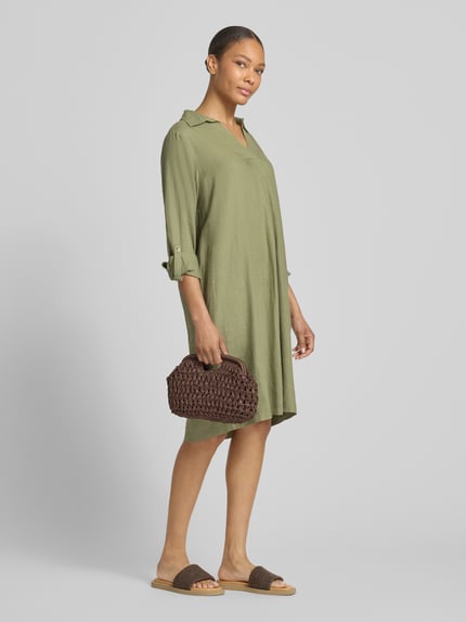 Vrouwenmodel draagt Figurhumspielendes Freizeitkleid uit linnen-viscose-mix van s.Oliver RED LABEL, effen kleuren, flatteus model, midilengte, V-hals, lange mouw met turn-up, gevlamd garen, materiaalverwerking, mix van linnen en viscose. Ganzkörperansicht von vorne.