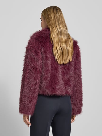 Vrouwenmodel draagt Regular Fit Jacke aus Teddyfell Modell 'NORA' van Vero Moda, uni bordeaux, langarm, recht model, rugaanzicht.