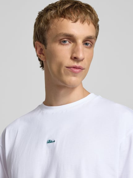 Männermodel trägt Regular Fit T-Shirt mit Logo-Stitching von BLKVIS in Weiß, reine Baumwolle, Rundhalsausschnitt, Nahaufnahme Oberkörper.