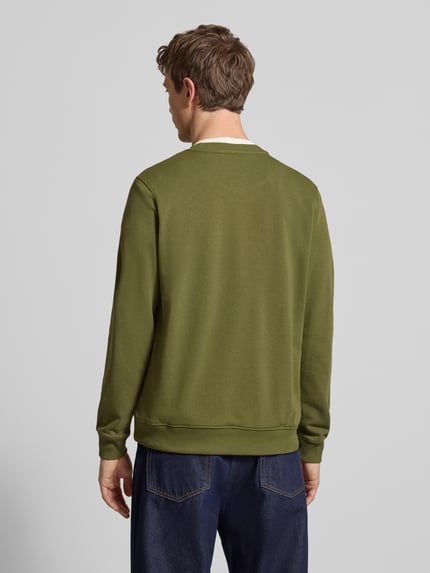 Männermodel trägt Regular Fit Pullover mit Logo-Stitching Modell 'Kane' von Blend, katoenmix, ronde hals, elastische boorden, modelkleur groen, jeans, ruglengte 68 cm, mouwlengte 67 cm, Ganzkörperansicht Rückansicht.
