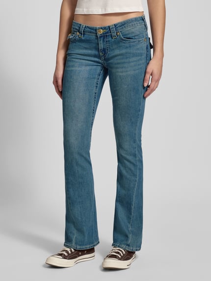 Modelka nosi Low Rise Flared Jeans mit Eingrifftaschen Modell 'JOEY' od TRUE RELIGION, jasnoniebieski, bawełna, używany look, widok z przodu, ujęcie całej sylwetki.