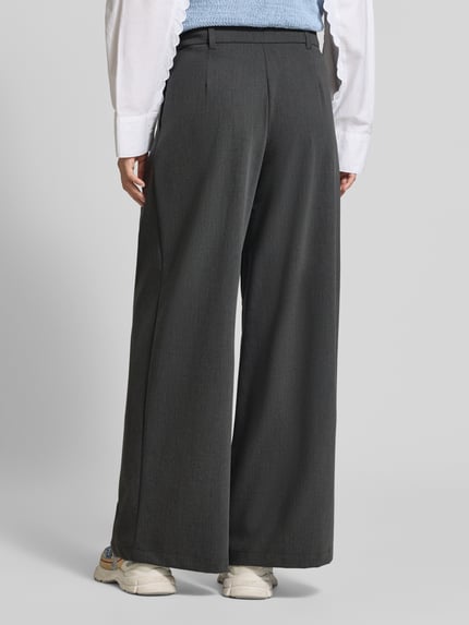 Frauenmodel trägt Weite Hose mit Viskose-Anteil Modell 'STELLA' von VERO MODA in Dunkelgrau, glatte Struktur, Ganzkörperansicht Rückansicht. Damen Weite Hose von VERO MODA.