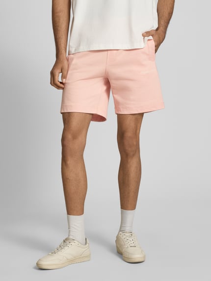 Männermodel trägt Sweatshorts mit Stitching Modell 'KARL' von Jack & Jones, rosafarbener Baumwoll-Mix, Regular Fit, Ganzkörperansicht von vorne.