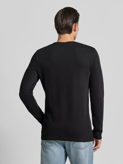 Männermodel trägt Regular Fit Longsleeve aus reiner Baumwolle Modell 'Basic' von Lindbergh in Schwarz, glatte Struktur, Ganzkörperansicht Rückansicht. Rückenlänge bei Größe M: 73 cm.